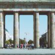 people under brown building with 6 pillars